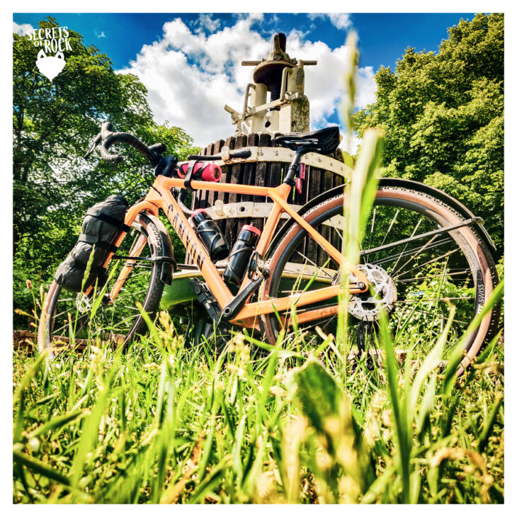 Foto von unten aus Gras-Perspektive zu meinem Fahrrad, welches an einer alten Holz-Weinpresse steht. Irgendwo in Schriesheim
